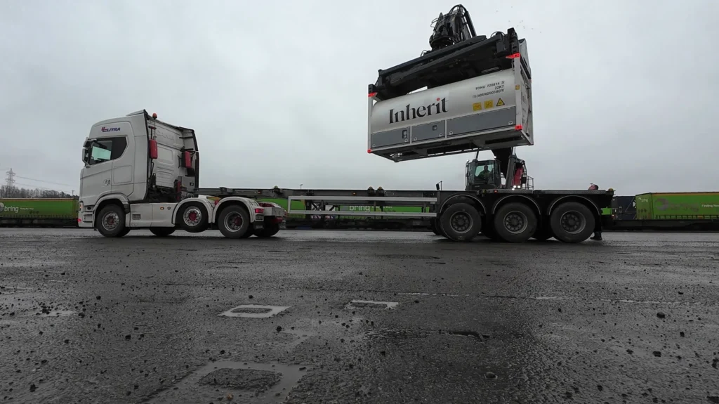 Reach stacker loading an Inherit-branded Bofort CO2 ISO tank onto a truck