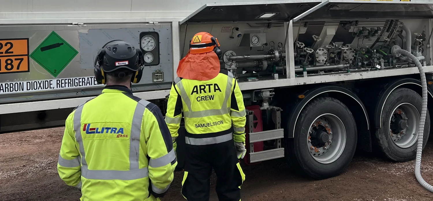 Two technicians in hard hats at the valve cabinet of a Bofort liquid CO2 ISO tank